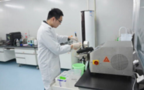 Technician working at a laboratory instrument in a clean room
